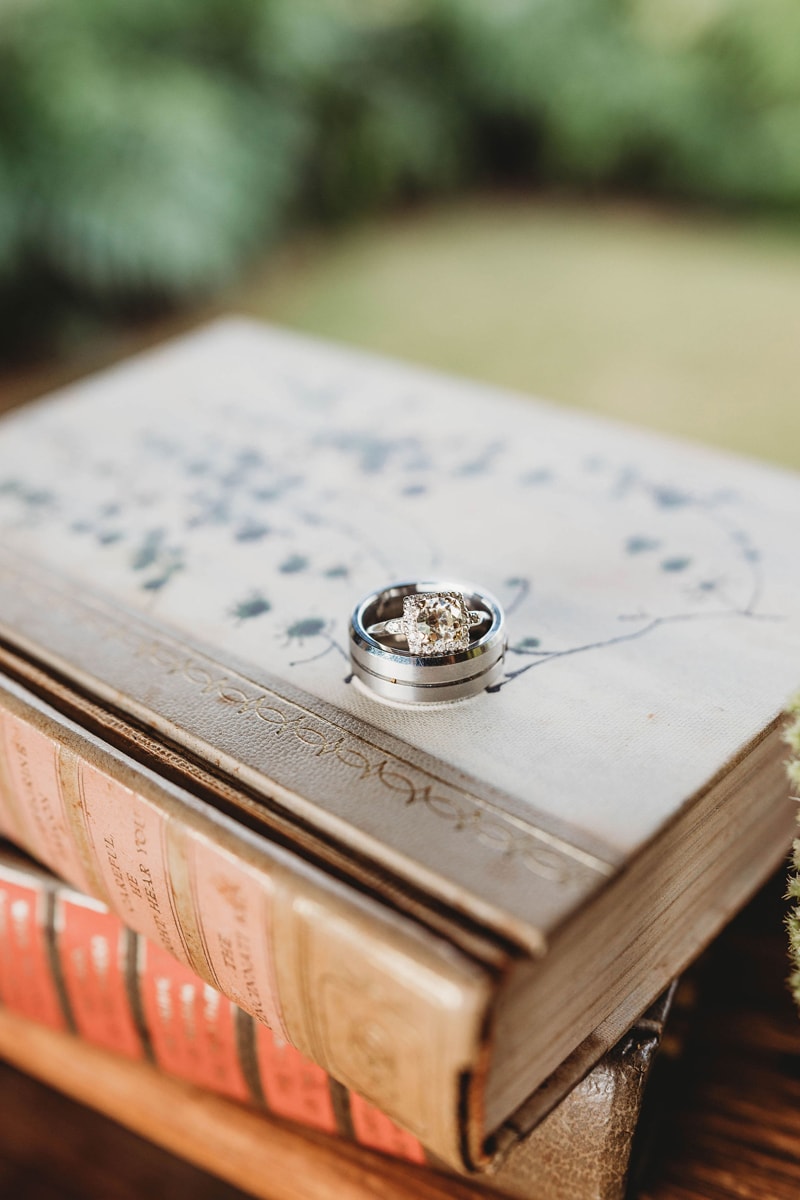 Wedding & Elopement Photographer, wedding rings sit atop old ornate books