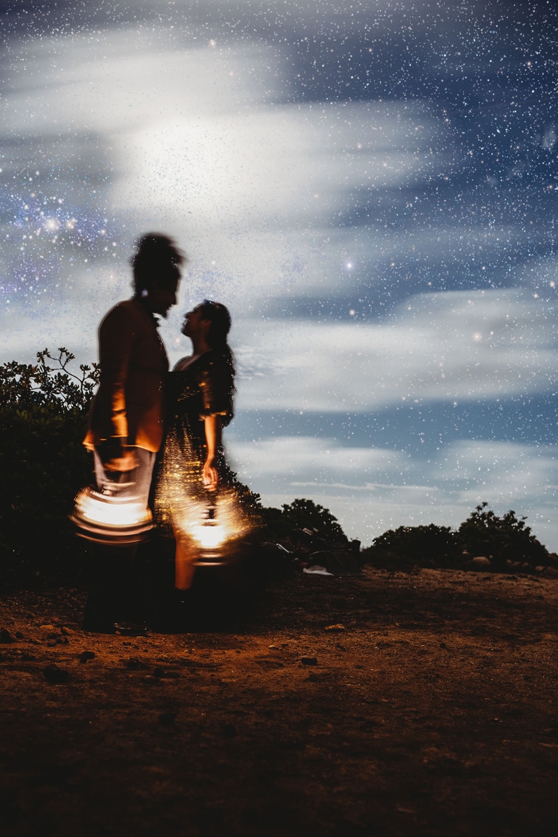 Wedding and Photographer, the silhouette of a couple standing together beneath the stars, their lanterns illuminate them