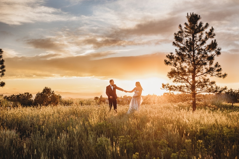 Wedding and Elopement Photographer, bride and groom dance in dry grassy meadow at golden hour