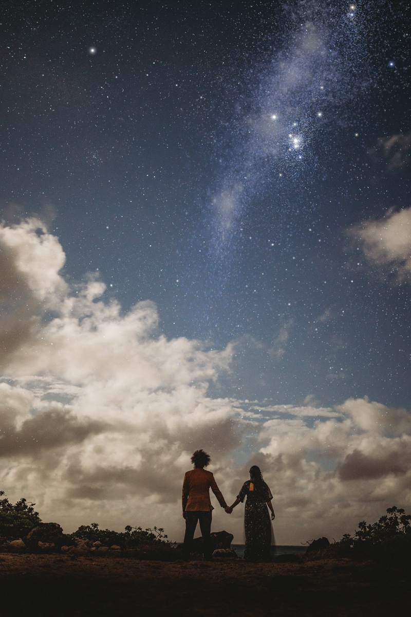 Wedding & Elopement Photographer,  bride and groom stare up as they hold hands beneath a star-studded sky
