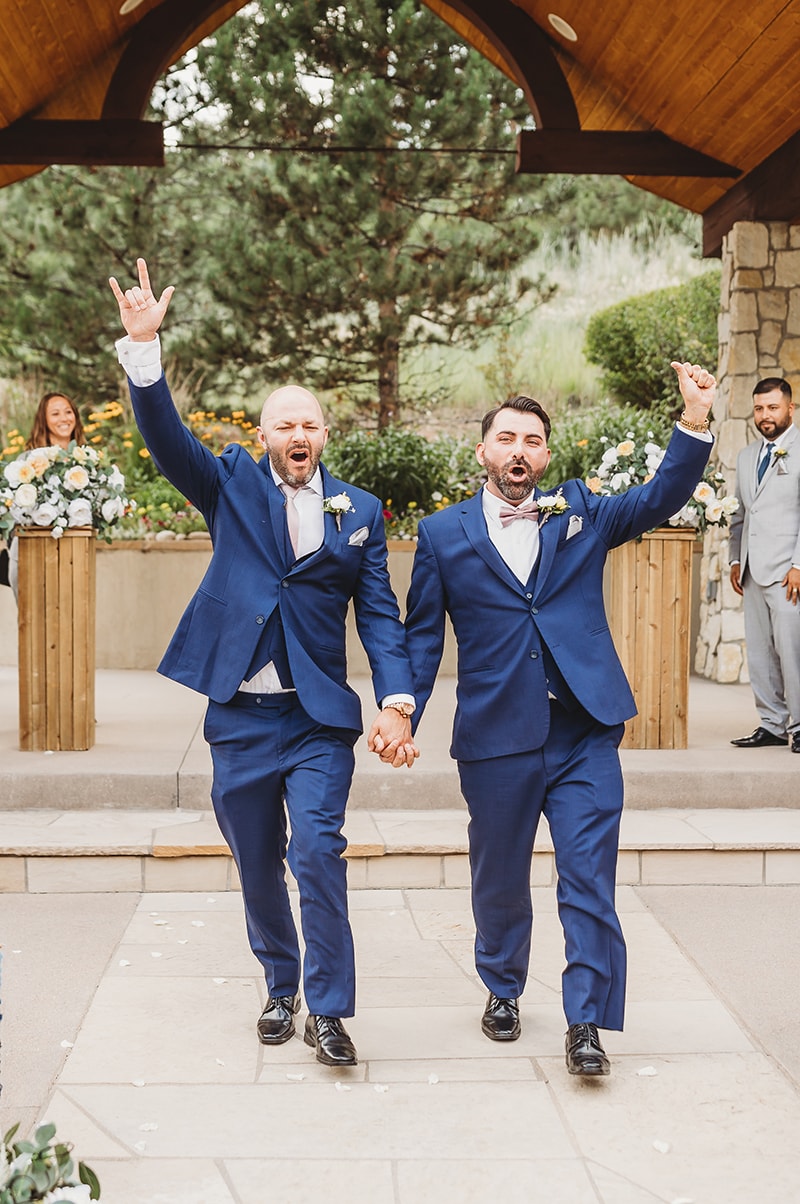 Wedding & Elopement Photographer, two grooms hold hands and cheer having just been married
