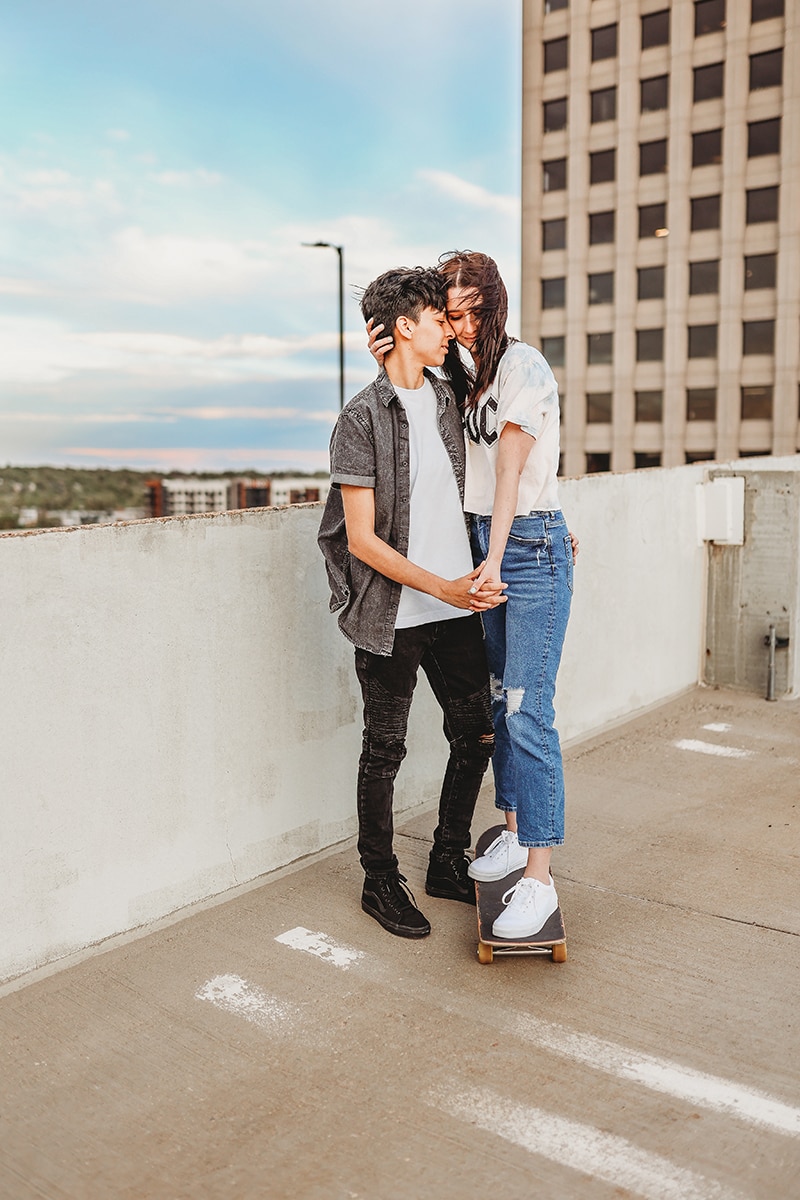 Wedding and Photographer, two partners hold each other in a city scape, one woman stands on a skateboard