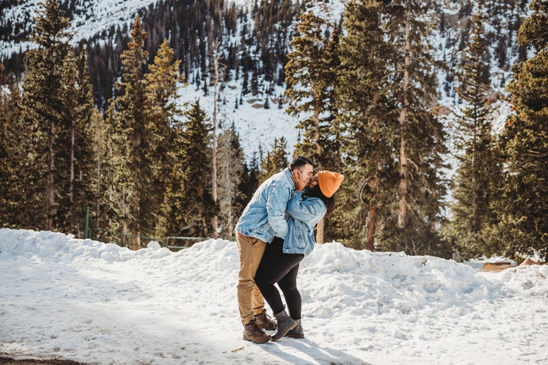 Wedding and Elopement Photography, man and w0man kiss and embrace in the snow covered mountain forests