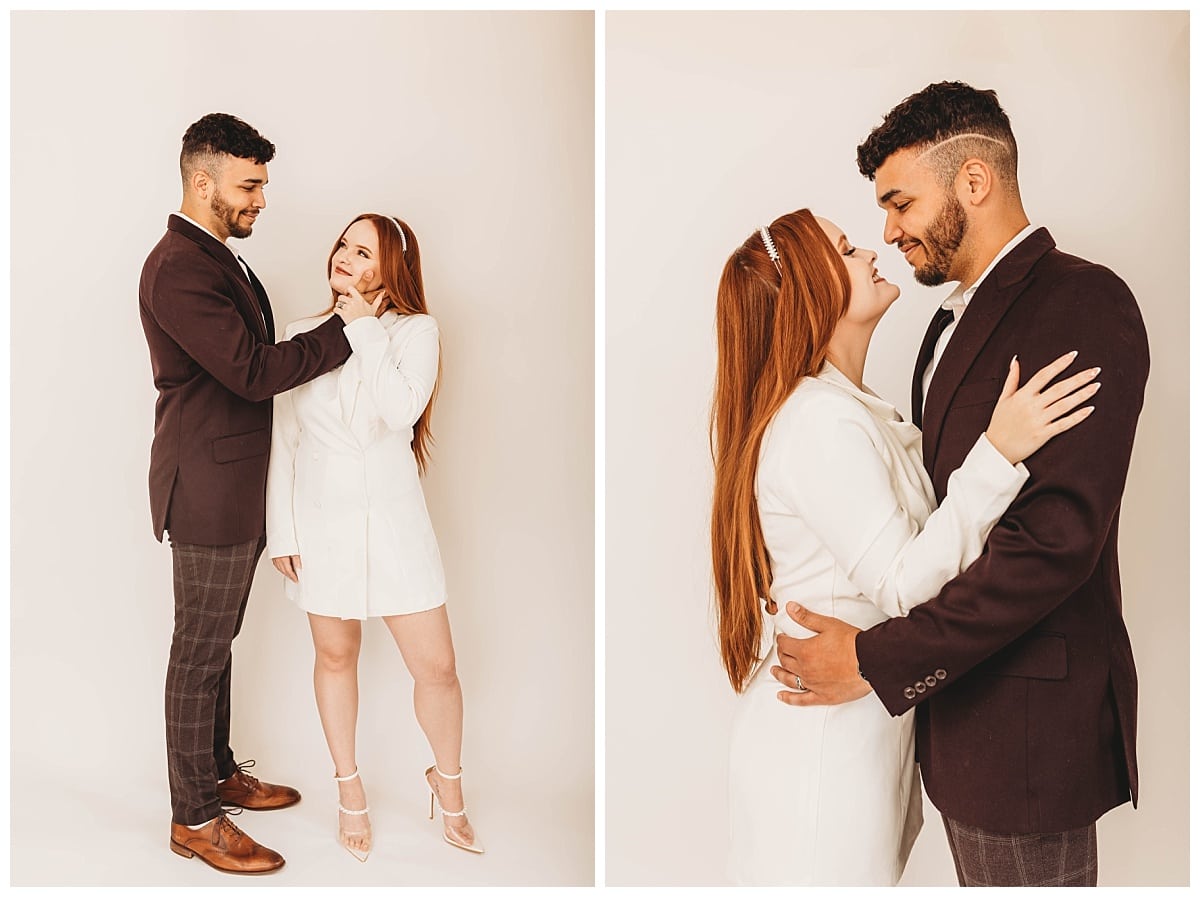 bride in a tuxedo dress and groom holding her face, couple studio photos, couple in love