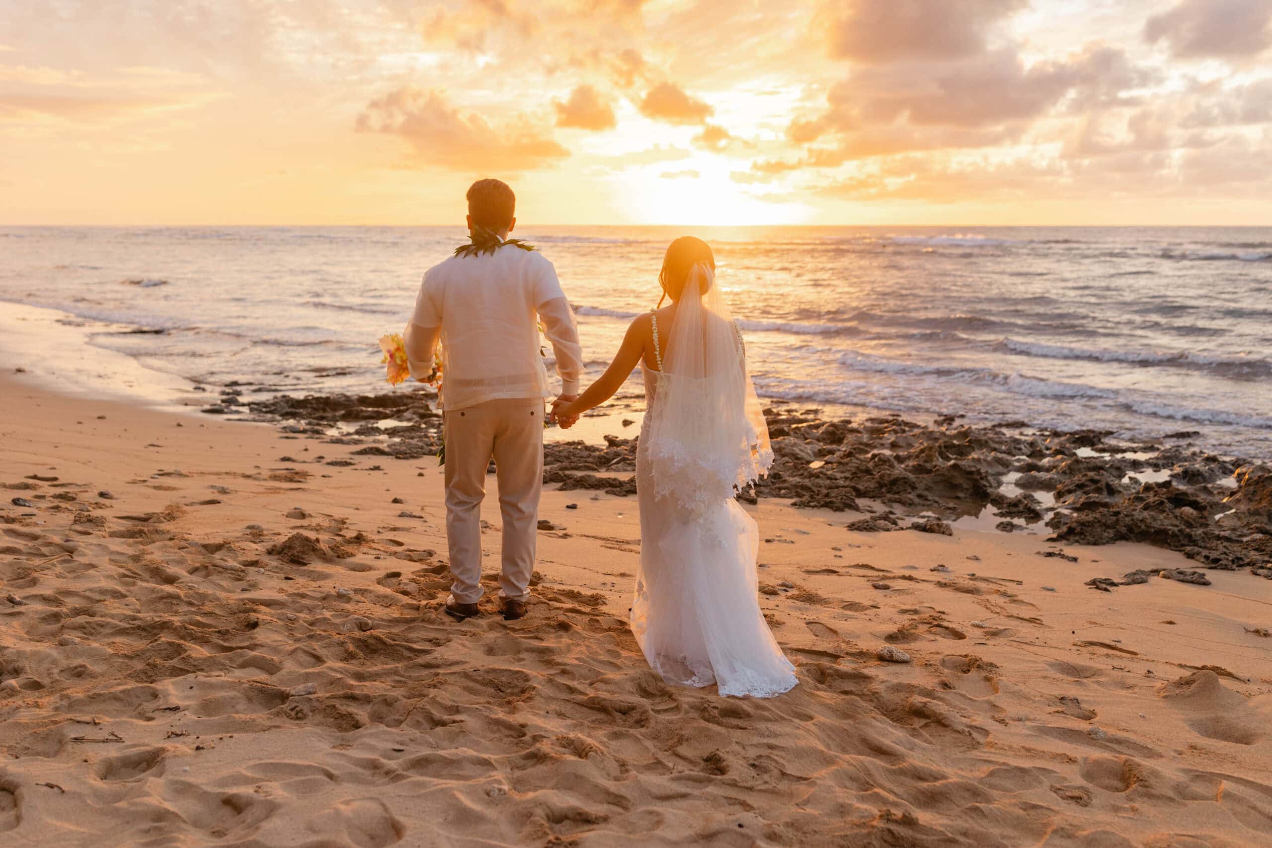 A bride and groom taking wedding photos on a beach