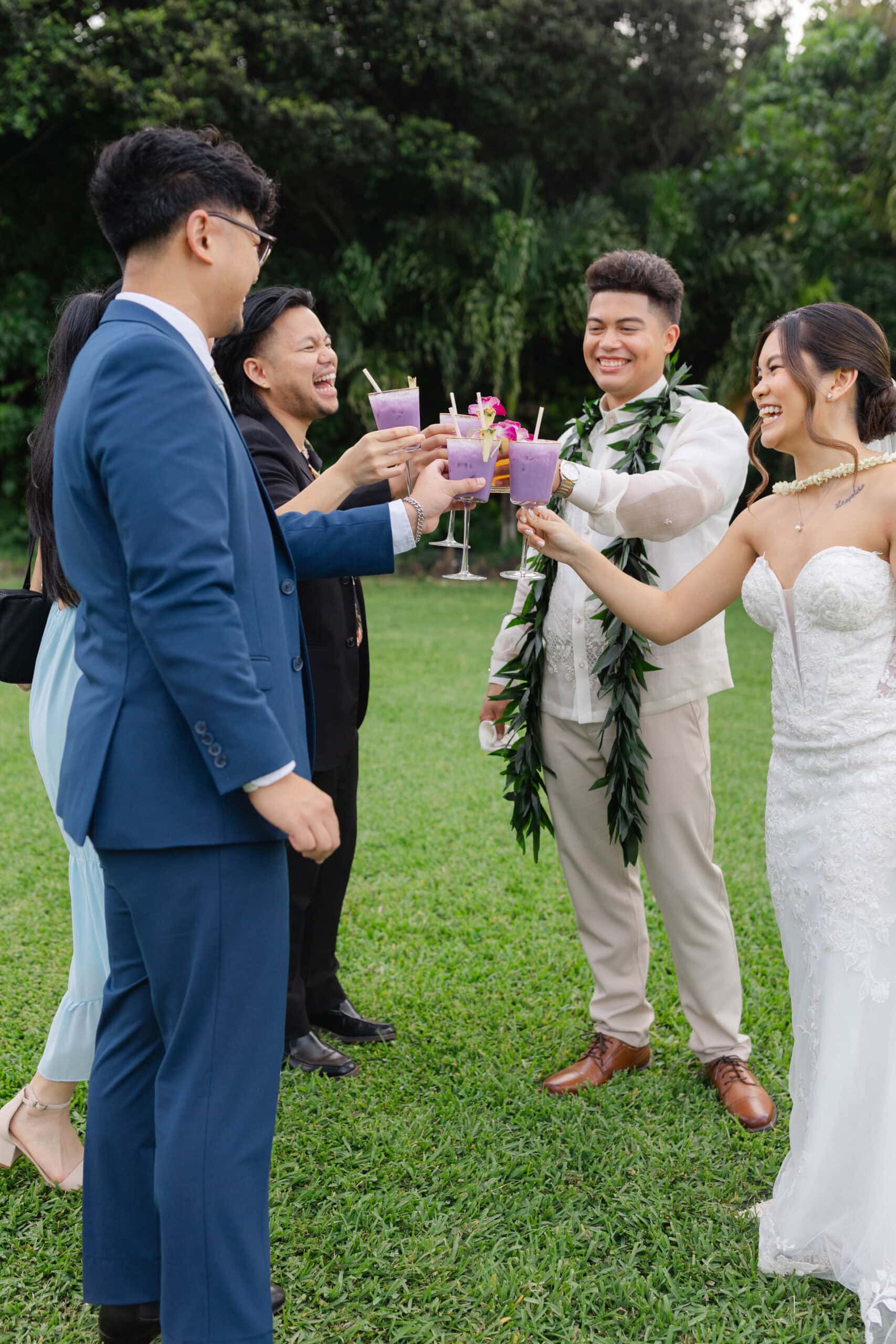 A bride and groom clinking drinks with wedding guests