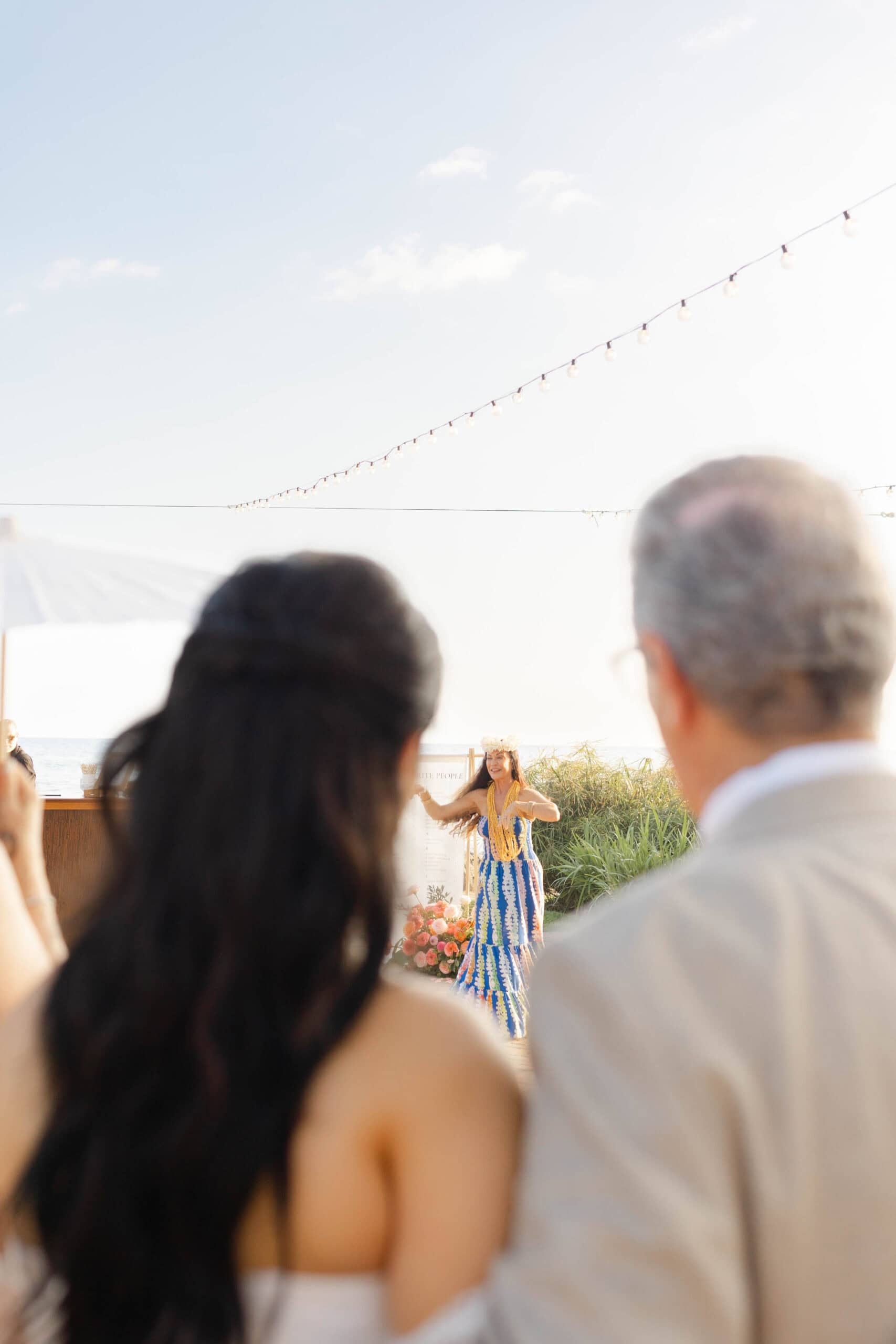 A bride and her father watching a dancer at a Maui wedding