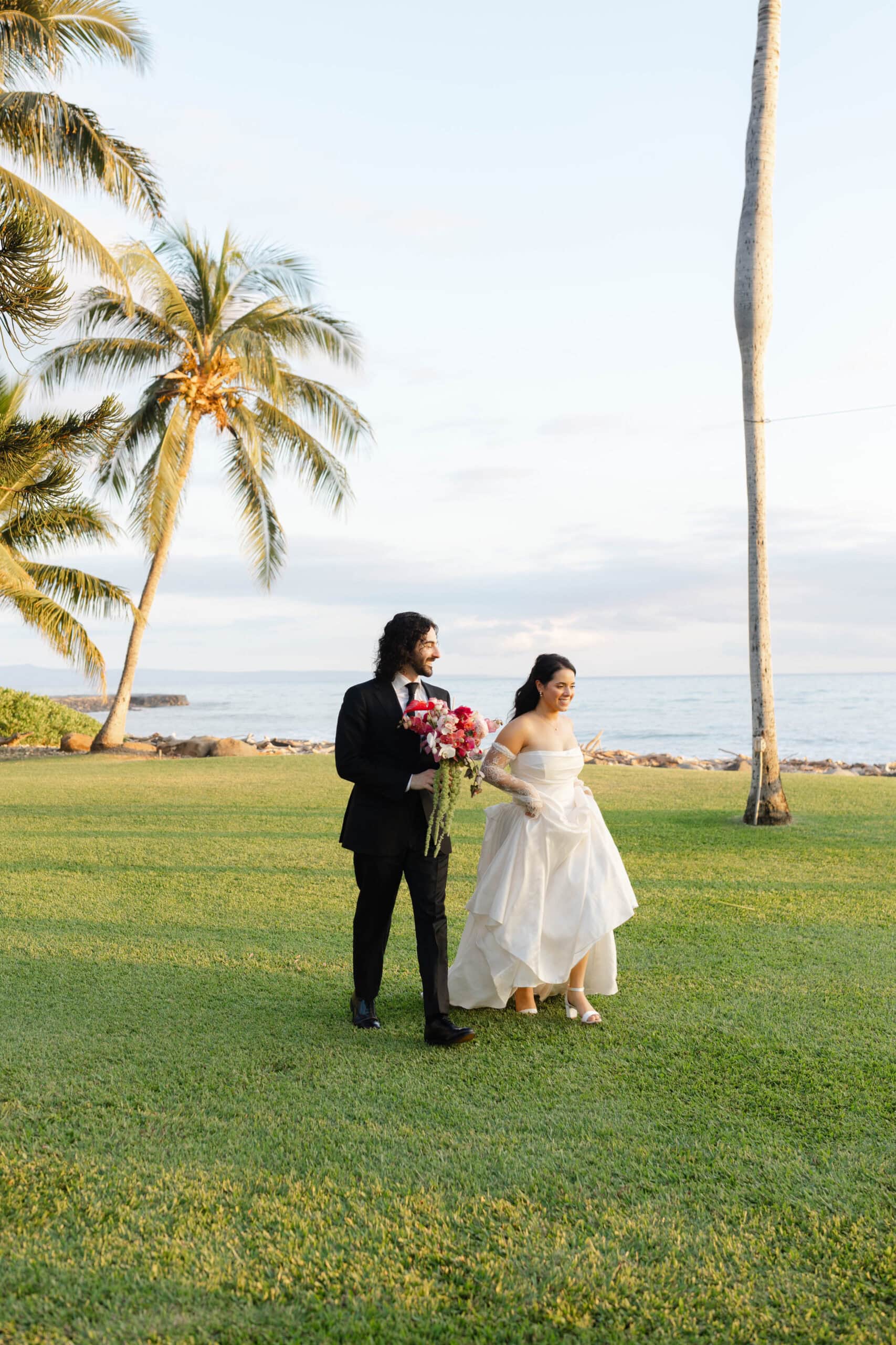 A bride and groom walking through their Maui wedding venue, Olowalu Plantation House