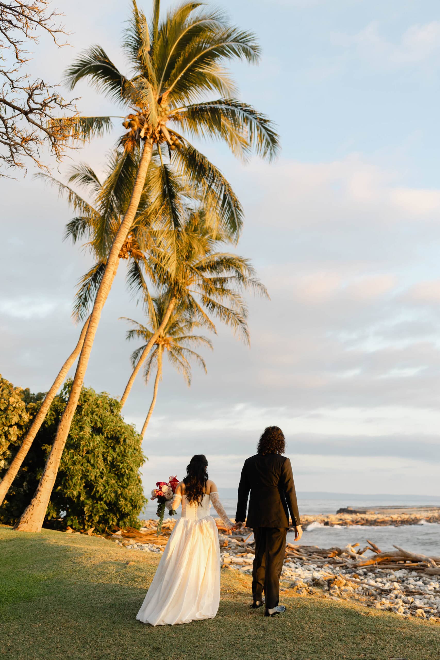 A bride and groom walking through their Maui wedding venue, Olowalu Plantation House