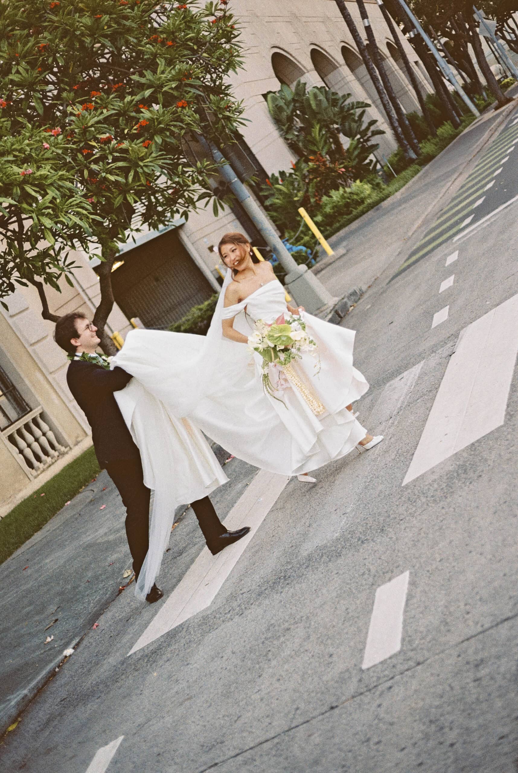 A bride and groom crossing the street