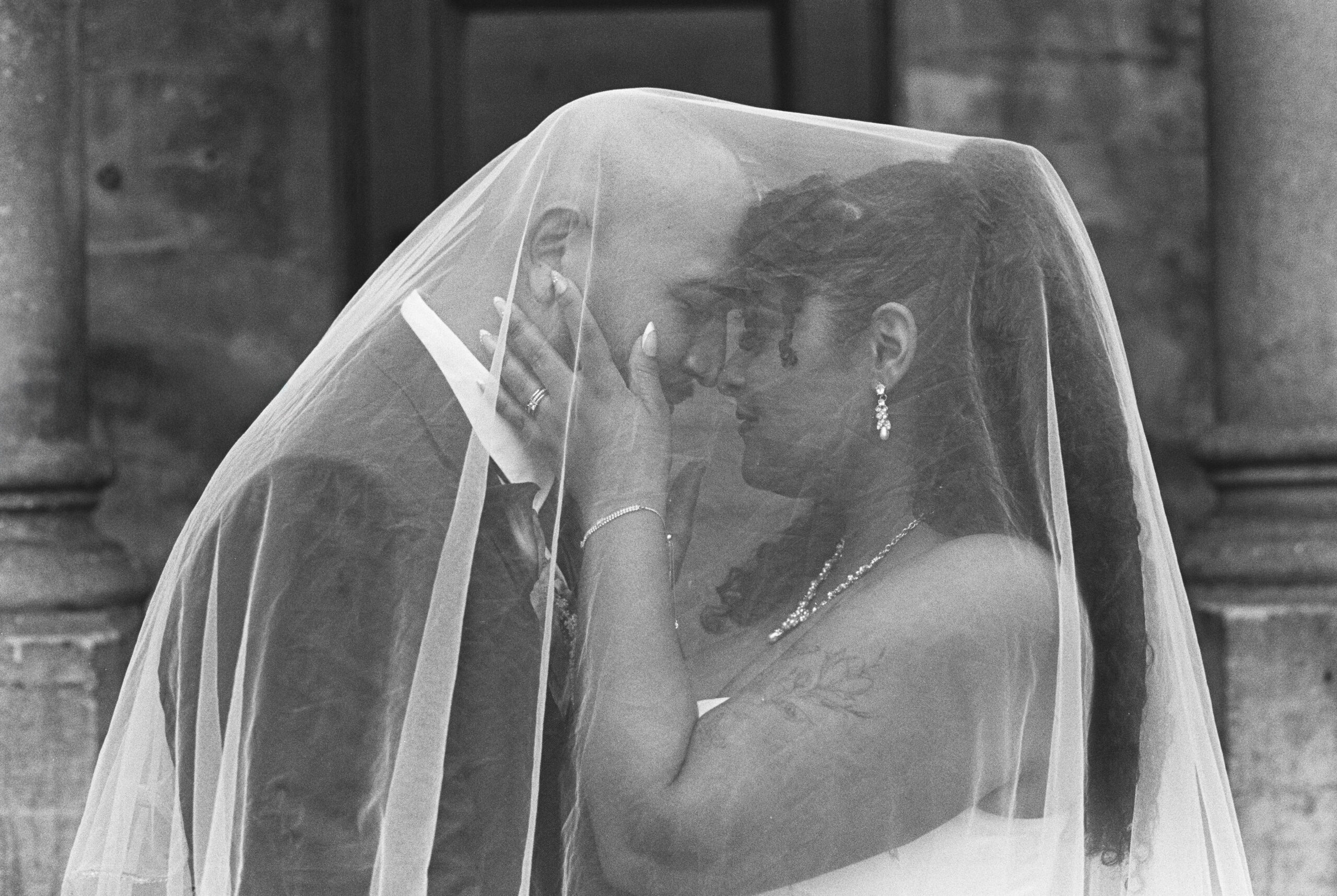 A bride and groom underneath a veil at their St. Louis wedding venue